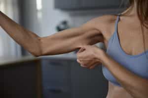 woman checking arm skin after weight loss