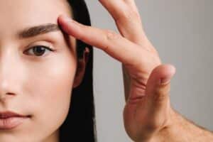 What Is an Endoscopic Brow Lift? 2 a hand and half a woman's face